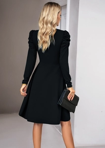 Detail of elegant black V-neck dress featuring puff sleeves and an A-line silhouette