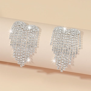 Macro detail of long tassel heart earrings with sparkling rhinestones for party wear