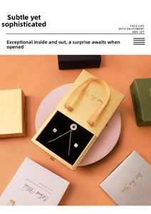 Detailed view of a gold necklace and stud earrings set in a luxury drawer gift box