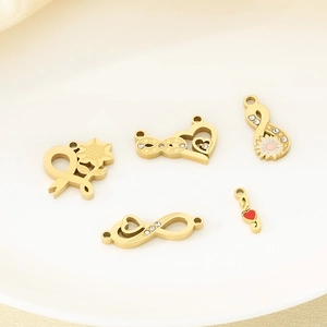 Detailed view of 18K gold-plated stainless steel charms with crystal and enamel accents