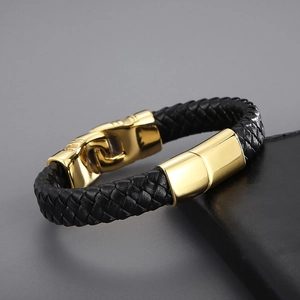 Close-up of black braided leather bracelet with a polished gold magnetic metal clasp