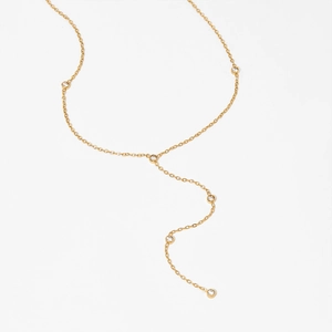 Minimalist gold Y-shaped necklace with five bezel-set zircon stones on white background