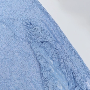 Dettaglio ravvicinato del tessuto in pizzo floreale azzurro con delicati motivi all'uncinetto