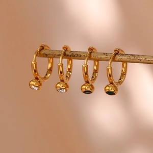 Macro shot of 18K gold plated hoop earrings featuring green and clear zircon drop charms