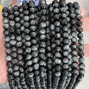 Detailed close-up of grey natural eagle eye stone round beads with chatoyant cat eye effect