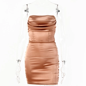 Détails de la robe moulante en satin champagne avec fronces élégantes et décolleté bustier