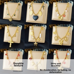 Detail view of gold necklaces with charms like flowers, butterflies, and stars