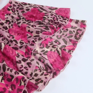Dettaglio di stampa leopardata e floreale rosa su tessuto mesh con volant a strati