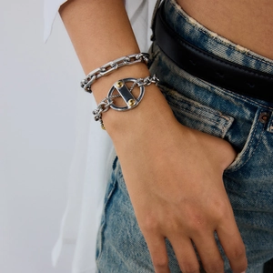 Gros plan de bracelets gourmettes punk en acier titane argenté portés au poignet
