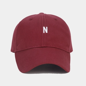 Close-up of burgundy cotton baseball cap featuring a white embroidered letter N