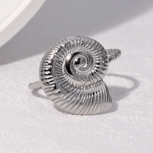 Macro detail of silver nautical nautilus shell ring with textured handmade metal band