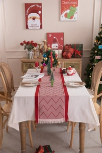 Detail of red and white herringbone table runner with handmade tassels for Christmas decor