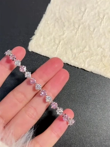 Detailed macro view of square-cut pink and white zircons on a silver-tone tennis bracelet