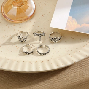 Vintage silver S925 flower and butterfly open ring set of five on a ceramic dish