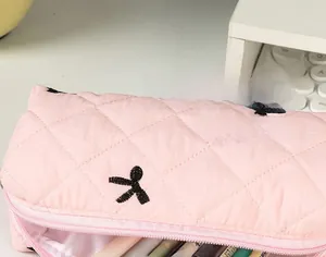 Detailed macro view of pink quilted fabric pencil case with black star embroidery