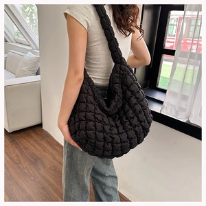 Detail of black quilted puffer tote bag with soft cloud texture on nylon fabric
