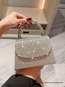 Detailed shot of a silver rhinestone evening handbag with a spiral-wrapped handle