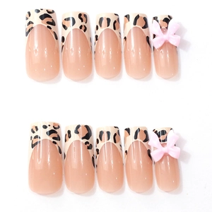 Detail of leopard print French nails with 3D pink bows and glossy translucent base