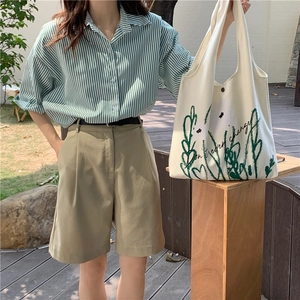 Detail of chamomile print canvas tote bag with floral pattern and text on casual outfit