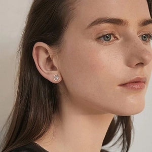 Close-up of S925 silver tree of life and crescent moon stud earrings with zircon on a model