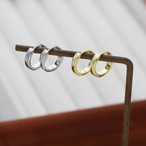Detail showing high-polished gold and silver S925 sterling silver hoop earrings with 925 stamps