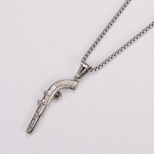 Macro shot of silver vintage pistol pendant showing detailed metallic stainless steel texture