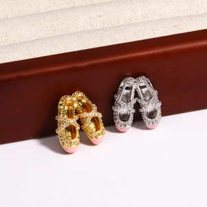 Detailed view of ballet slipper pendants with sparkling rhinestones in gold and silver