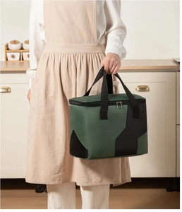 Close-up of military green insulated lunch bag with durable black nylon handles and zippers