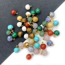 Close-up of assorted spherical natural stone charms with golden rings for DIY jewelry