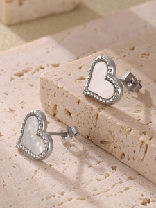 Macro detail of silver heart stud earrings with natural mother of pearl shell inlay