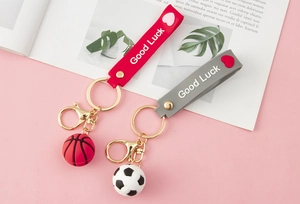 Detail of sports-themed keychains with basketball and soccer charms and silicone wristbands