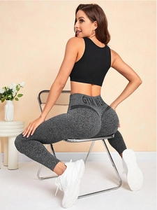 Détail du legging de yoga gris taille haute avec texte GYMWEAR et coupe sculptante corps