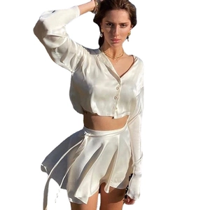 Ensemble chic deux pièces en satin blanc avec haut court à manches longues et mini-jupe