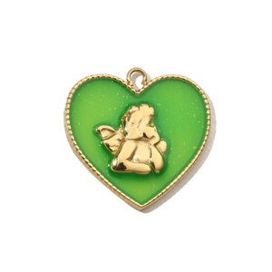 Dettaglio macro del ciondolo a cuore dorato con resina verde e rilievo di angelo