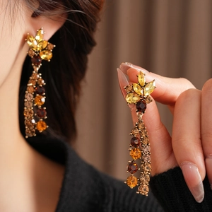 Detail von Vintage-Kronleuchter-Ohrringen in Gold mit bernsteinfarbenen Steinen