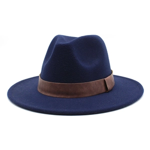 Detail of navy blue felt fedora hat featuring a brown leather band and flat wide brim