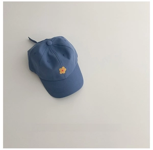 Détail d'une casquette enfant bleu marine avec broderie fleur et sangle de réglage arrière