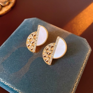 Macro shot of 18K gold plated D-shape earrings with mother of pearl and zircon details