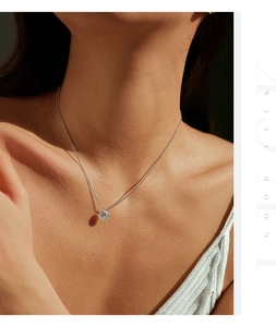 Close-up of D color moissanite pendant on silver chain worn by a model in soft lighting