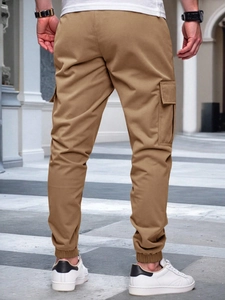 Outdoor back view of men's khaki slim fit cargo jogger pants with multiple pockets