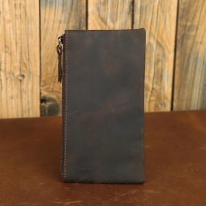 Detailed view of deep brown crazy horse leather wallet with vintage texture and side zipper