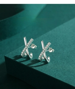 Detailed view of silver X-shaped crisscross stud earrings with pave-set zircon crystals