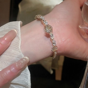 14k gold plated floral cuff bracelet featuring pear-cut zircon stones on a female wrist