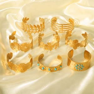 Golden stainless steel open bangles with floral and geometric leaf patterns on satin