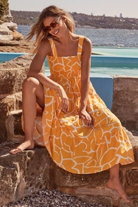 Detailed view of tiered summer dress featuring abstract prints and smocked bodice texture