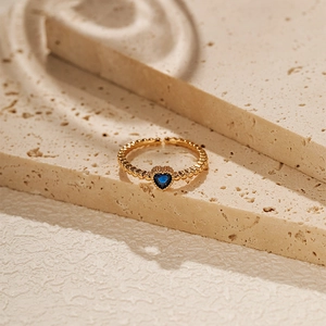 Macro view of 18K gold-plated adjustable ring with heart-shaped blue zircon and beaded texture