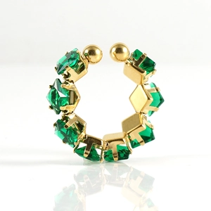 Detail van vergulde open ring met smaragdgroene vierkant geslepen zirkonia op witte basis