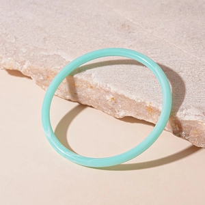 Détail d'un bracelet en acrylique vert menthe translucide avec une texture nuageuse