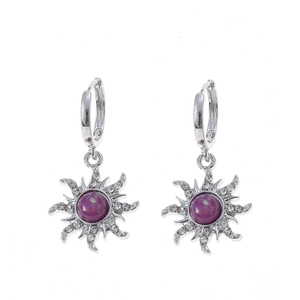 Close-up of silver sun-shaped stud earrings with purple gemstone and zircon accents