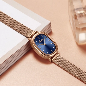 Elegant rose gold oval quartz watch with deep blue dial and mesh strap on a luxury background